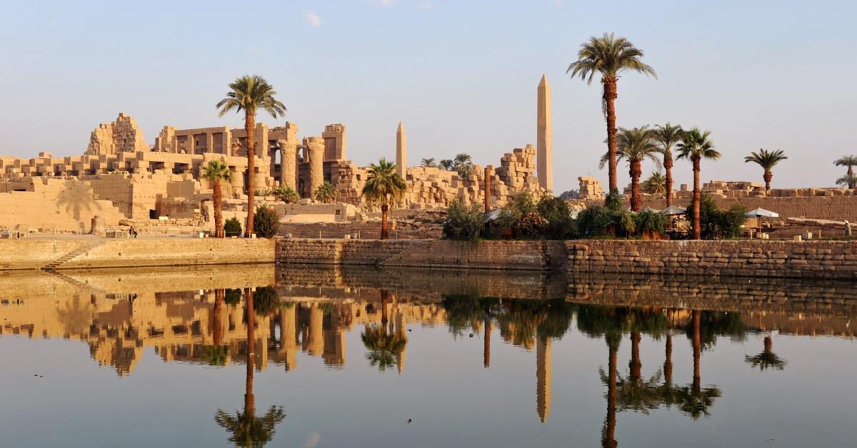 The Ancient Egyptian temple complex at Karnak reflecting on the Nile River.