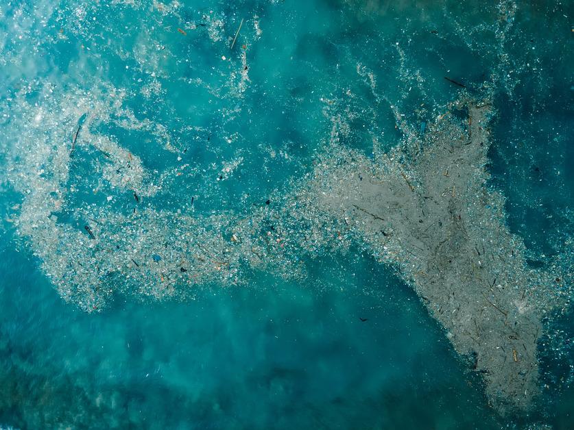 An aerial view of a plastic trash island in the ocean. 