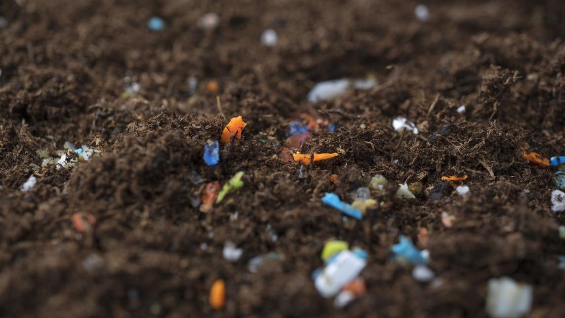 A stock photo of plastic pollution in soil